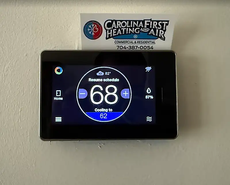 Wall-mounted smart thermostat with the faceplate open during installation