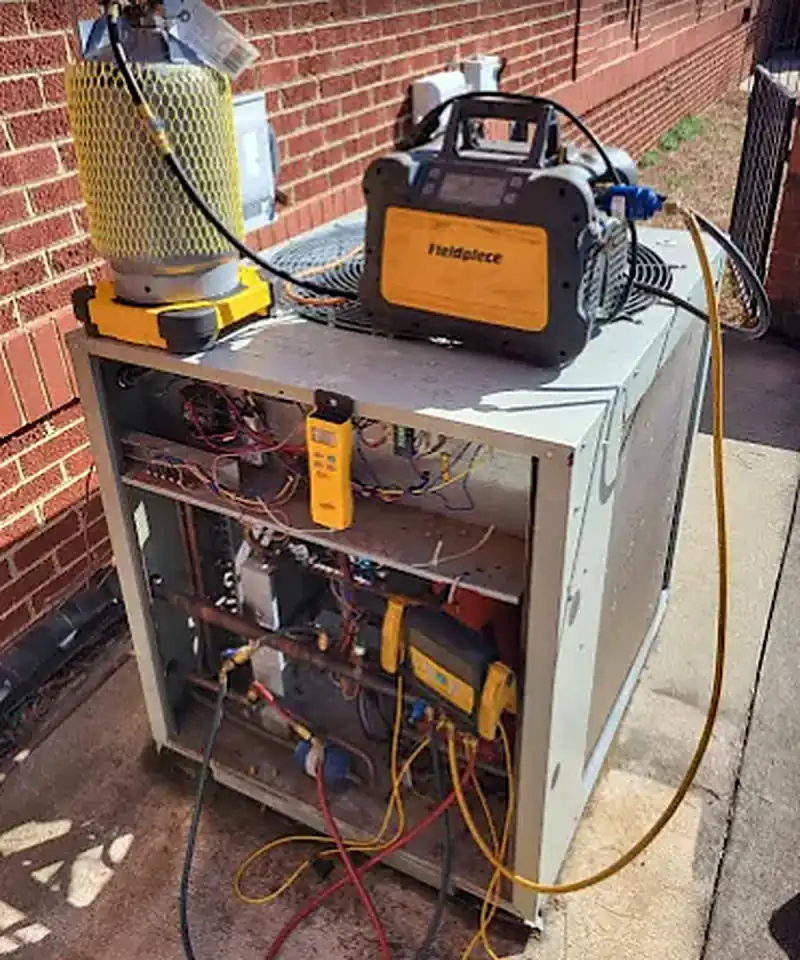 Refrigerant recovery tank and gauges connected during a commercial AC repair