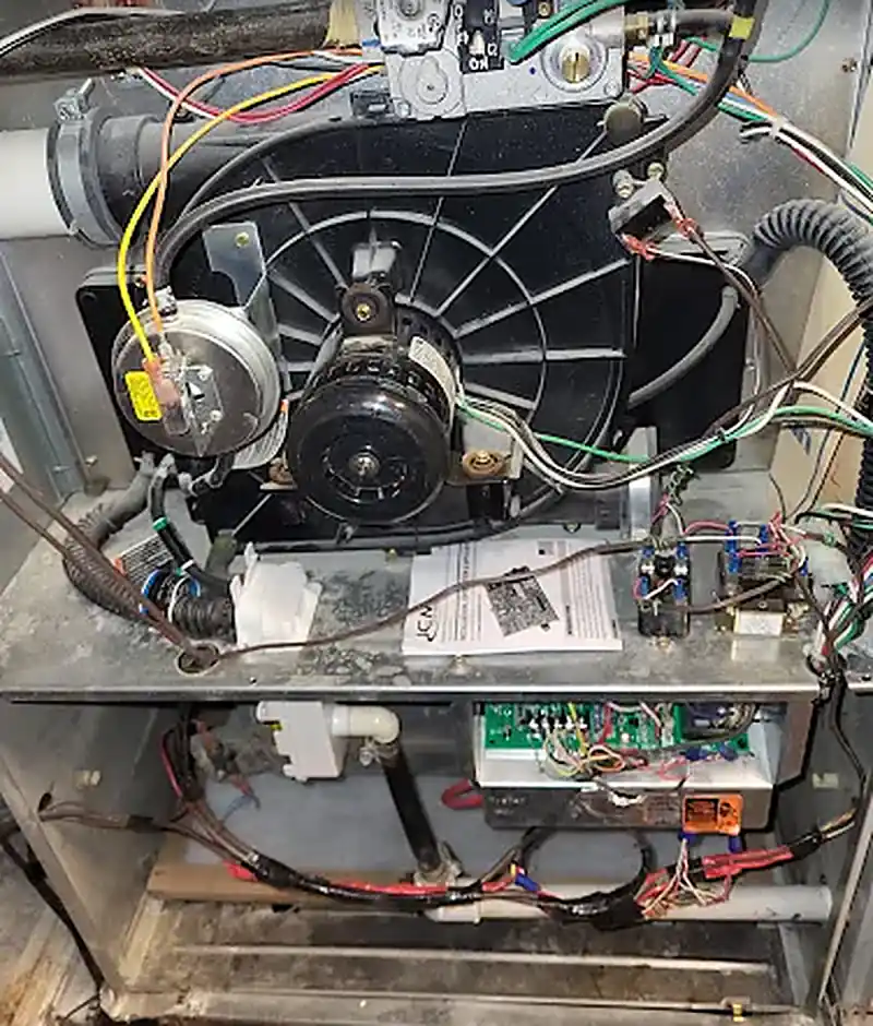 Gas furnace inducer motor and vent piping with the panel removed