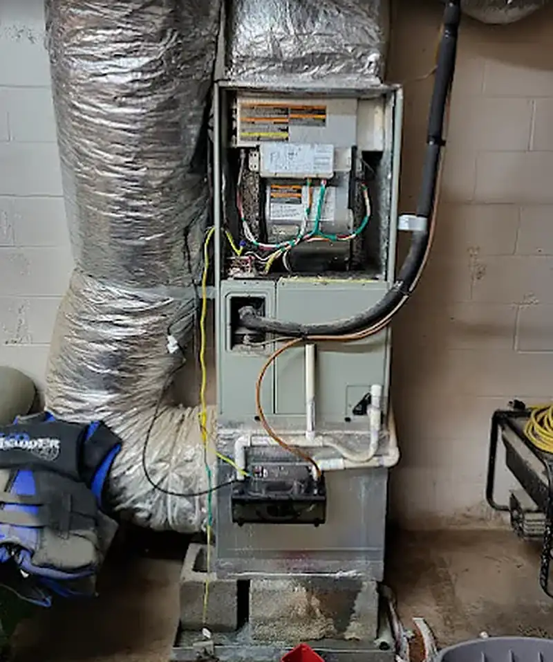 Technician inspecting the burners of a basement gas furnace